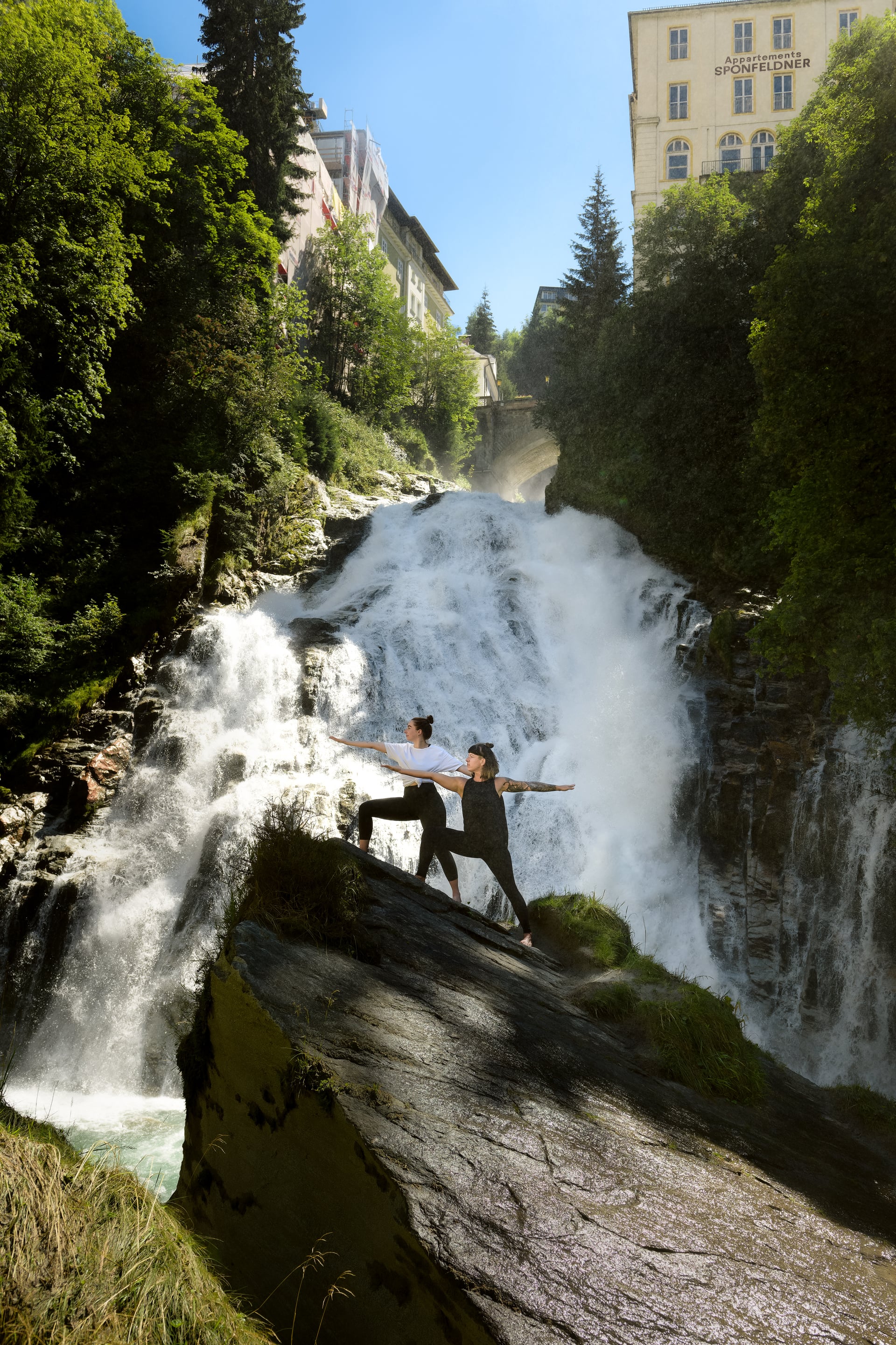 Zwei Frauen beim Yoga vor dem Gasteiner Wasserfall